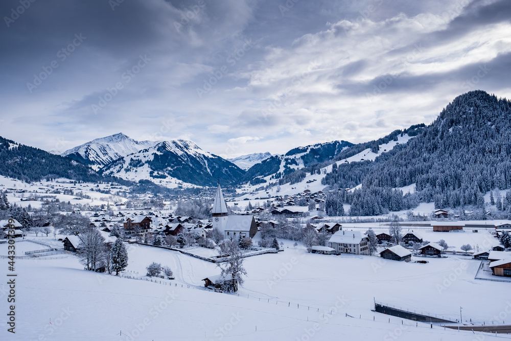 Scenic view of snowy village - Saanen, Switzerland