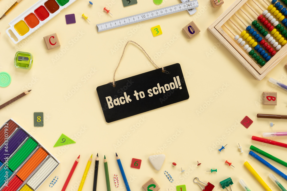 School and office supplies border on beige paper background. Multicolored pencils, paints, plasticine, abacus, pushpins and other school accessories School and office supplies border on beige paper background. Multicolored pencils, paints, plasticine, abacus, pushpins and other school accessories