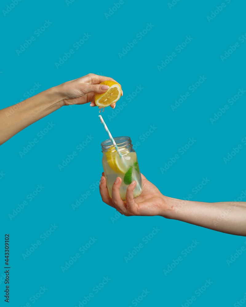 hand holds a jar with fresh cool lemonade