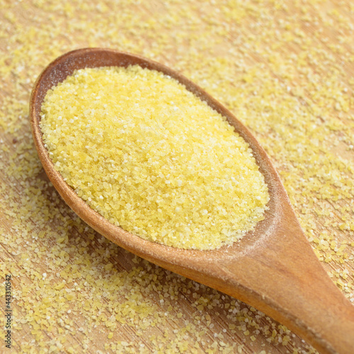 Fotografie Semolina made by grinding durum wheat, semolina irmik in a wooden spoon