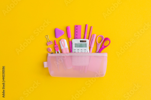 Pencil case with school stationery on a yellow background. Top view. Flat lay. Back to school concept.