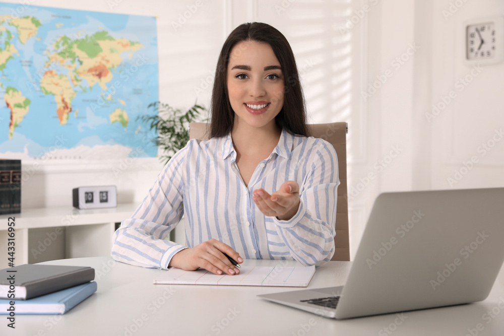 Happy manager sitting at desk in travel agency Happy manager sitting at desk in travel agency