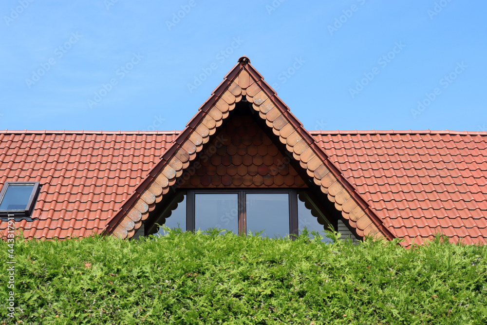 Spitzgaube mit Dach hinter einer grünen Hecke in Nordrhein-Westfalen, Deutschland