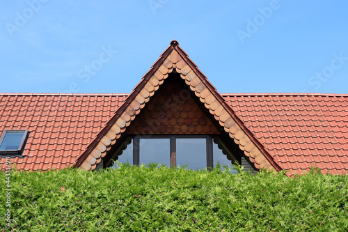 Spitzgaube mit Dach hinter einer grünen Hecke in Nordrhein-Westfalen, Deutschland