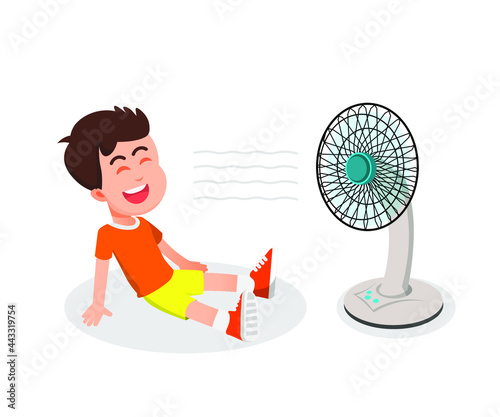 a boy uses a fan to cool his body