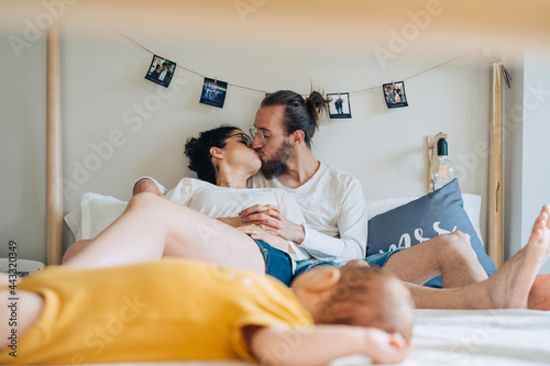 young couple spending time with new born baby in bedroom