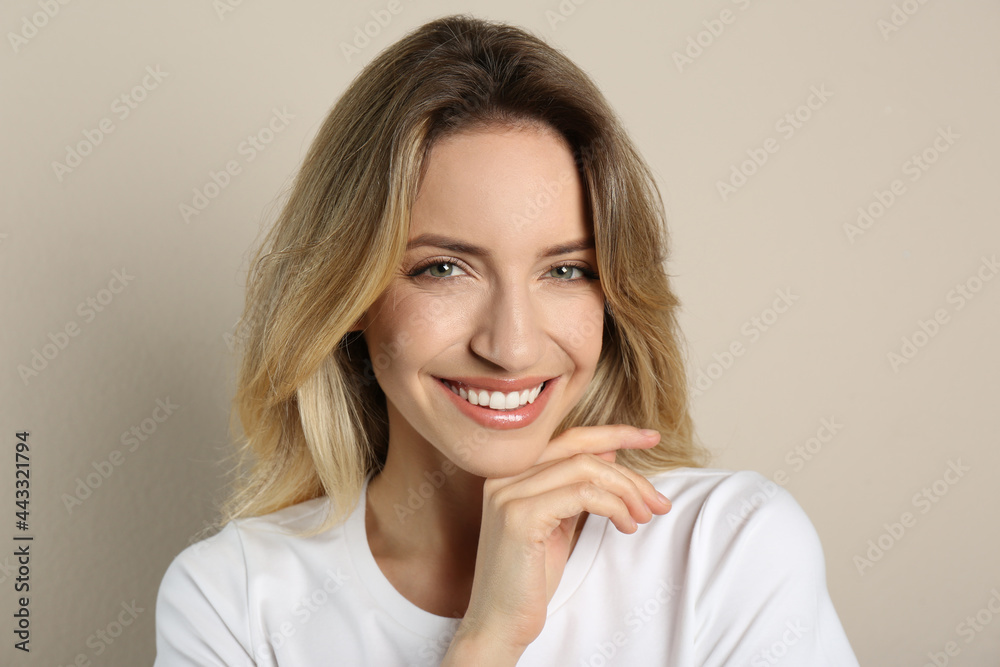 Portrait of happy young woman with beautiful blonde hair and charming smile on beige background Portrait of happy young woman with beautiful blonde hair and charming smile on beige background
