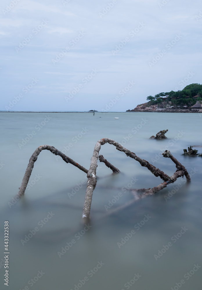 Fototapeta premium Old broken steps in the sea with long exposure and copy space