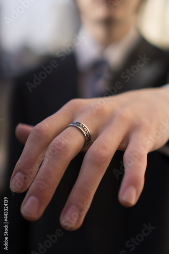 Close up of an elegant ring on manfinger. Outood shot with selective focus.