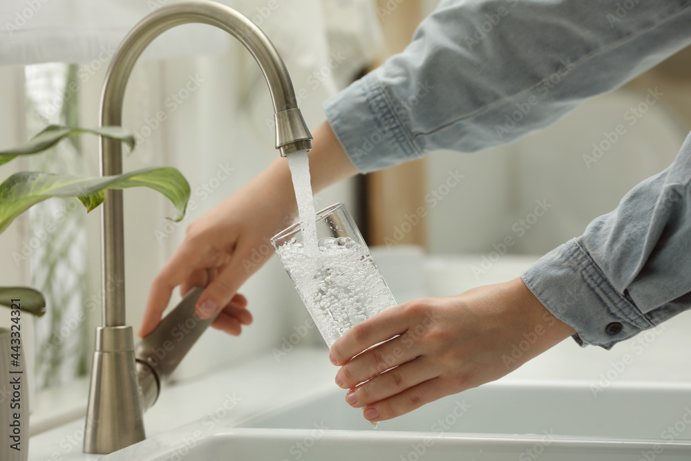 Woman filling glass with water from tap at home, closeup - obrazy, fototapety, plakaty 
