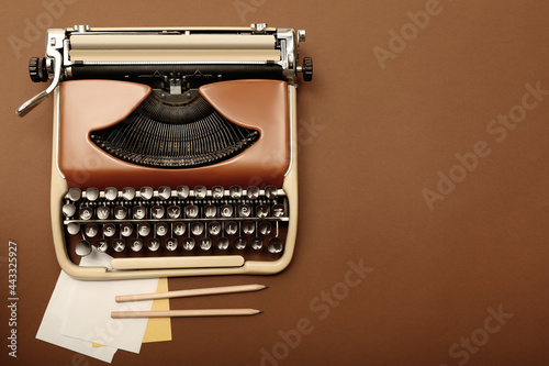 Vintage typewriter and stationery on brown background, flat lay. Space for text