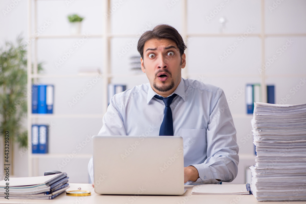 Young businessman employee unhappy with excessive work in the of Young businessman employee unhappy with excessive work in the of