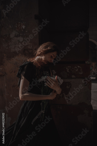 Curly girl in a black dress against the backdrop of the city