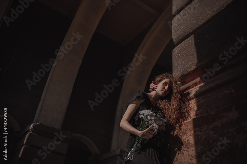 Curly girl in a black dress against the backdrop of the city © Ruslan