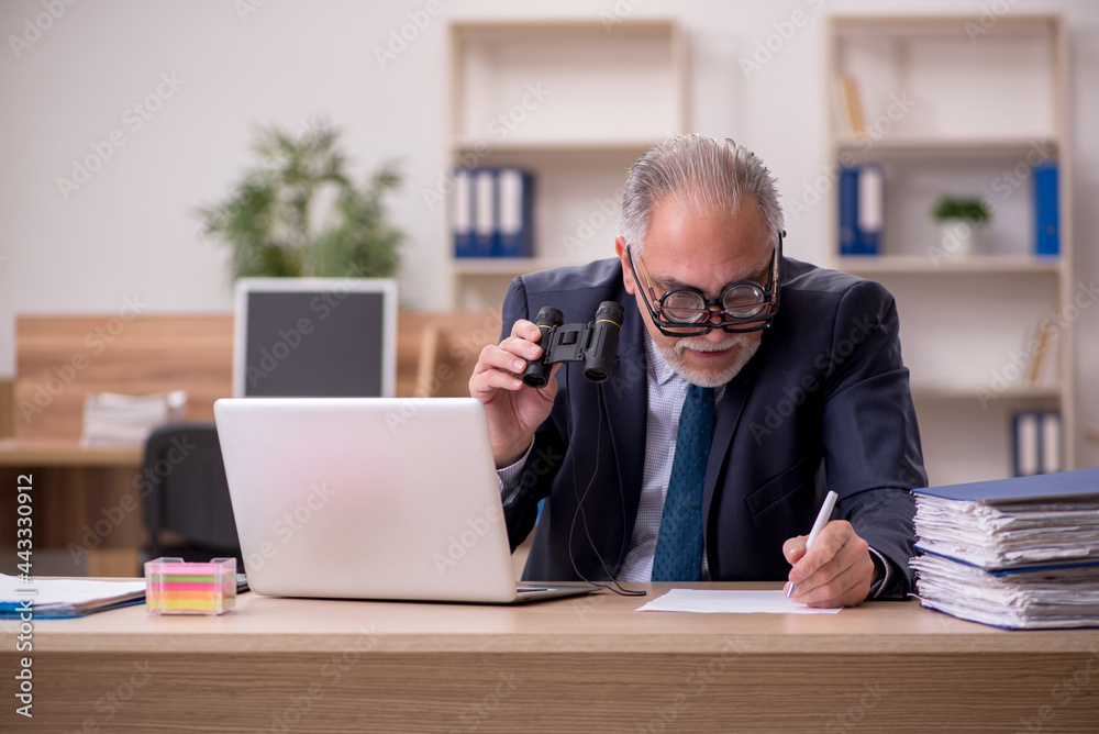 Old male employee auditor wearing many glasses at workplace Old male employee auditor wearing many glasses at workplace