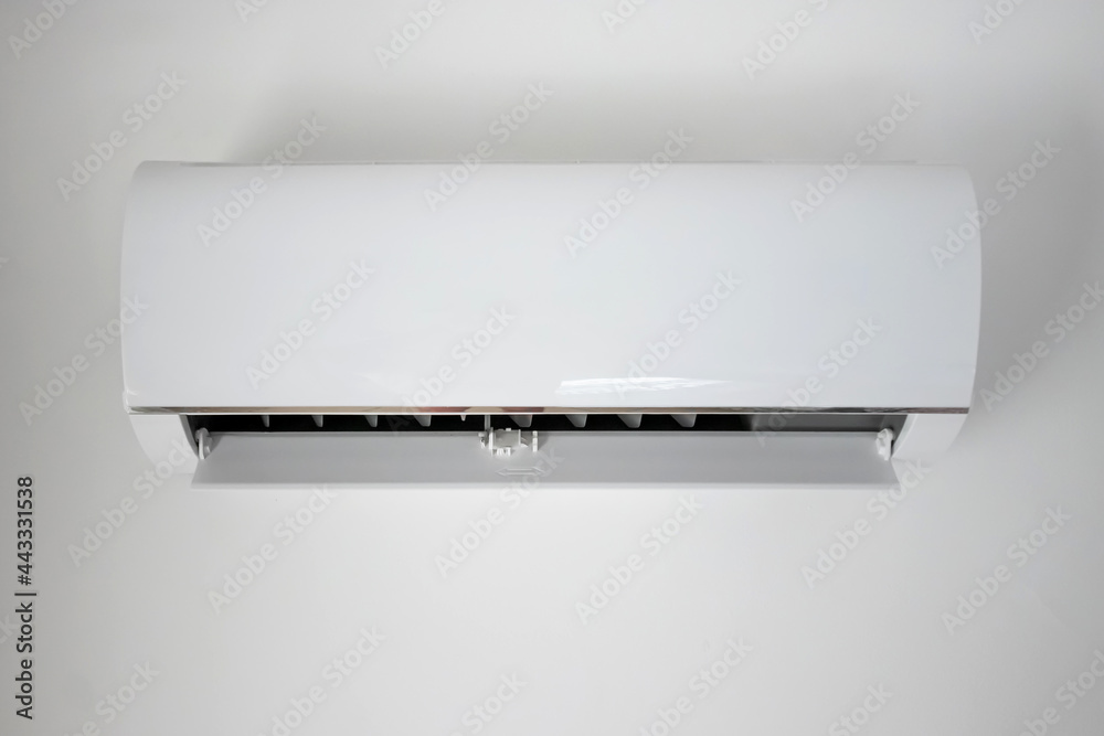 White air conditioner hangs on the wall. The cooling of the apartment, at home.