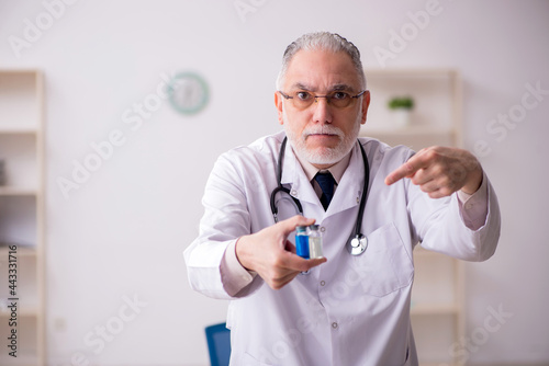 Old male doctor in vaccination concept