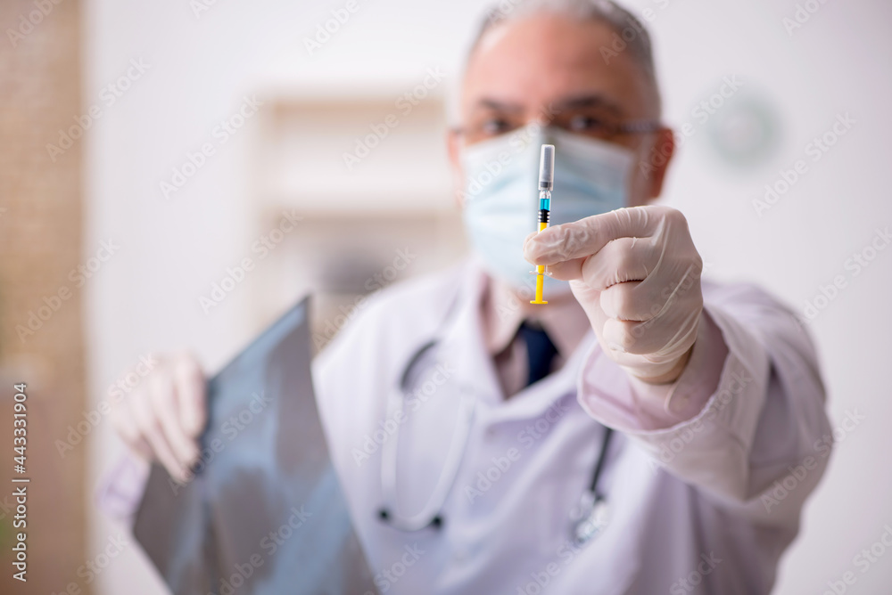 Old male doctor radiologist in vaccination concept Old male doctor radiologist in vaccination concept