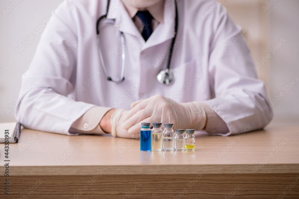 Old male doctor in vaccination concept