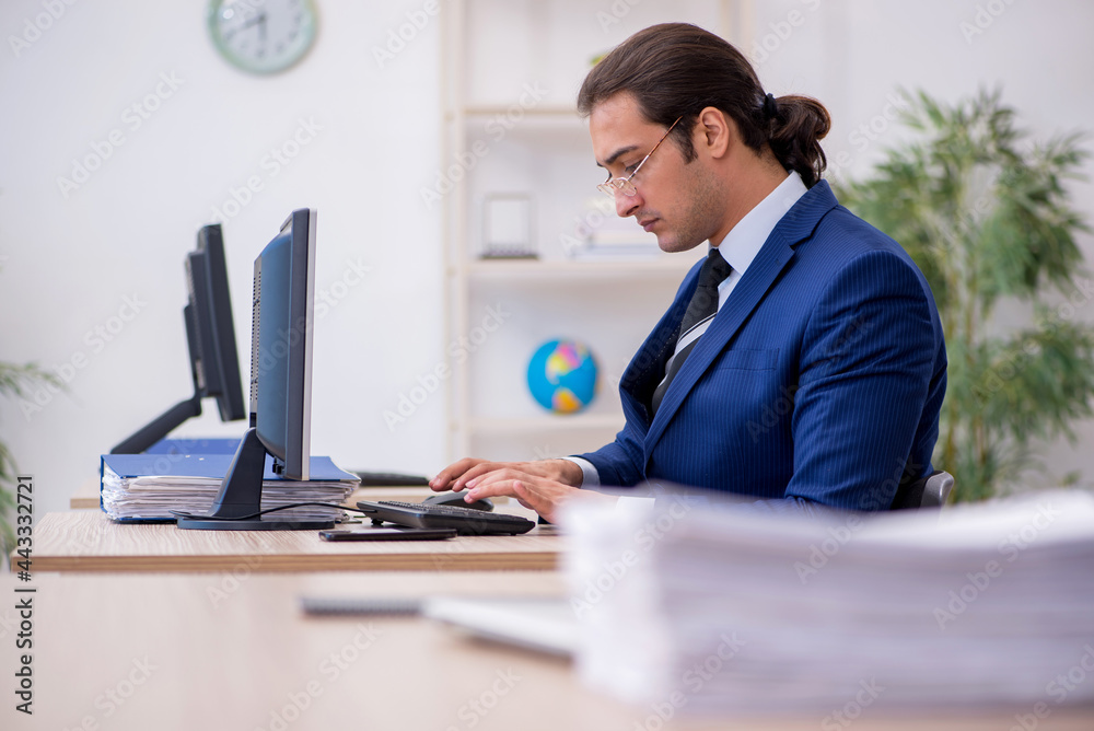Young male employee working in the office Young male employee working in the office