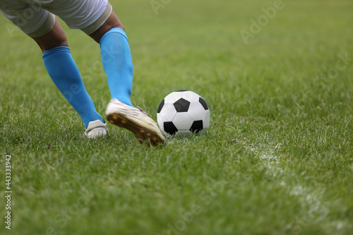 Fototapeta Naklejka Na Ścianę i Meble -  Close up of a football  with player  kicking the ball