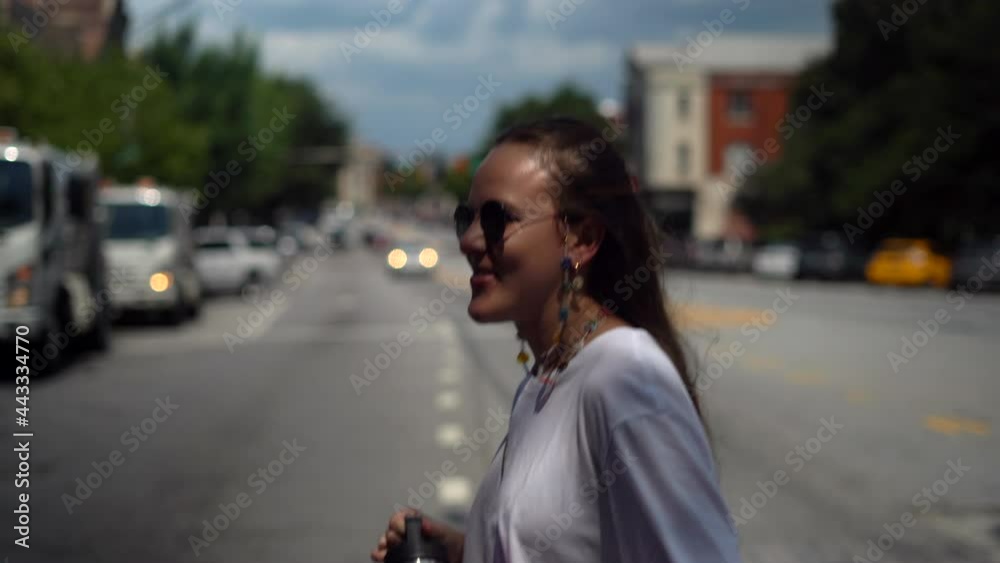 Happy young woman crosses the street in the center of a small town - isolated tracking view Happy young woman crosses the street in the center of a small town - isolated tracking view