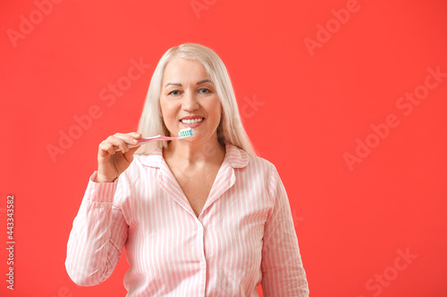Mature woman brushing teeth...