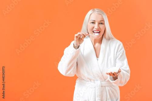 Mature woman brushing teeth...