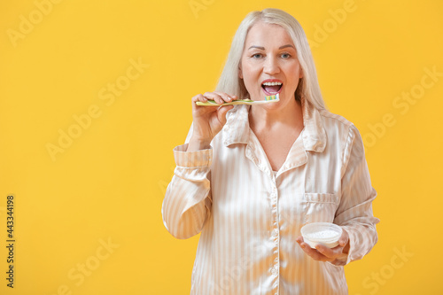 Mature woman brushing teeth...