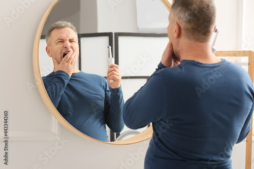 Mature man brushing teeth a...