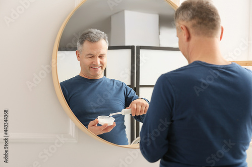Mature man brushing teeth a...
