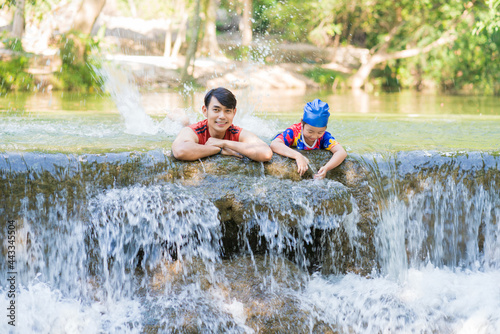 Happy Father with daughter enjoy the waterfall. Traveling nature near a beautiful waterfall at Chet Sao Noi waterfall National Park © CasanoWa Stutio