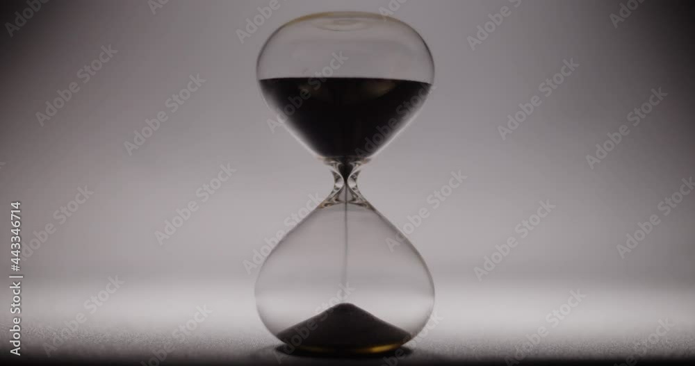 Timelapse of an hourglass cycle. White background. Abstract time waste concept. 