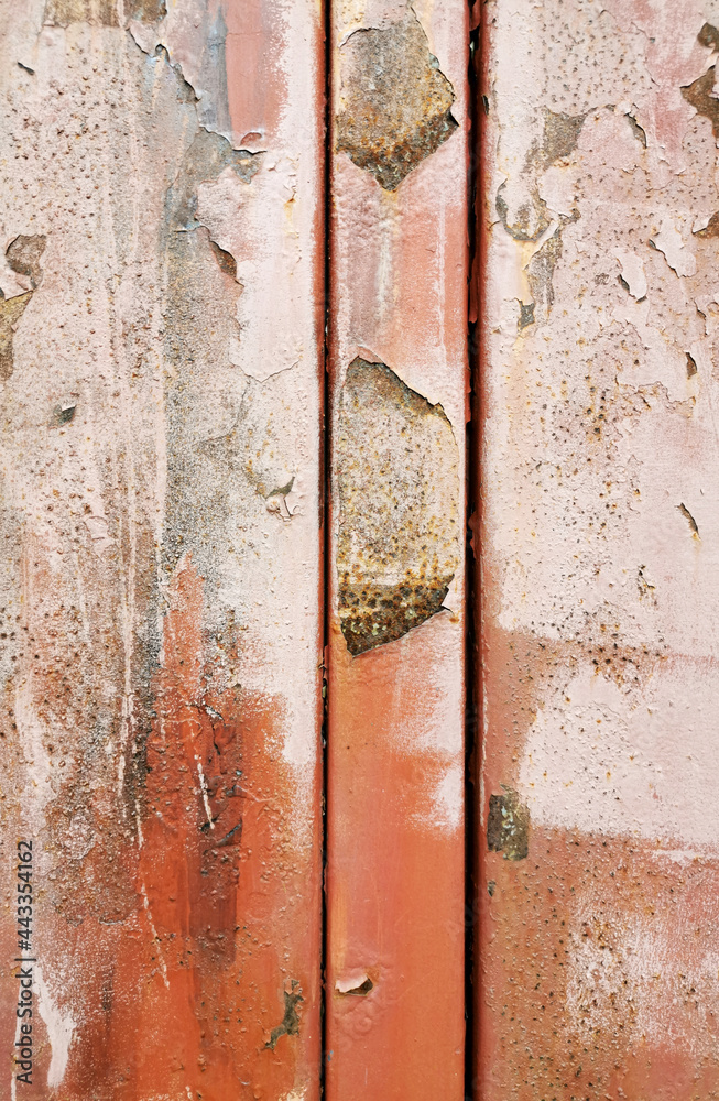 very old metal plates of red color with a crossbar with peeling paint covered with rust
