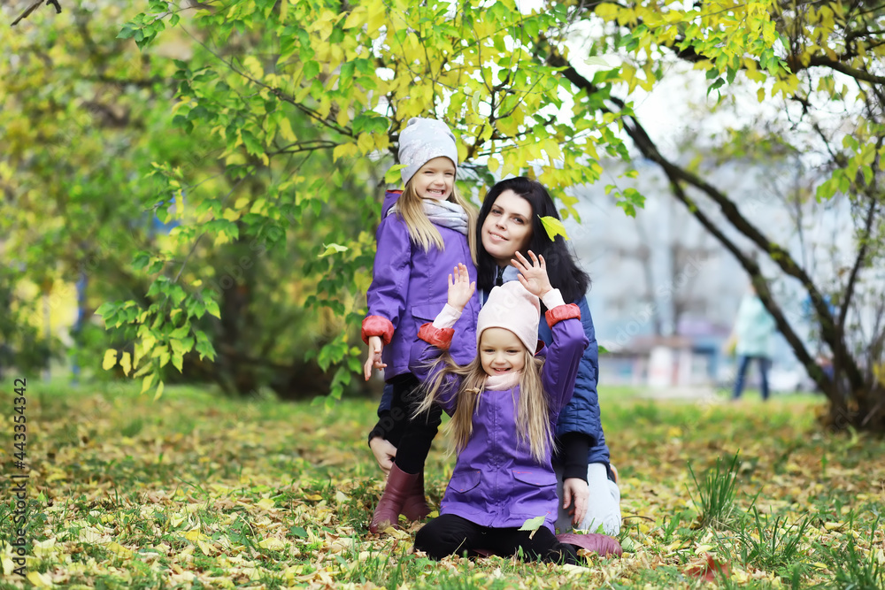 Fototapeta premium Leaf fall in the park. Children for a walk in the autumn park. Family. Fall. Happiness.