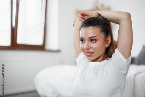 Young fit woman doing stretching exercises at home