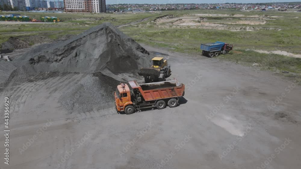 a loader loads a dump truck with gravel. aerial shooting 4k frame a loader loads a dump truck with gravel. aerial shooting 4k frame