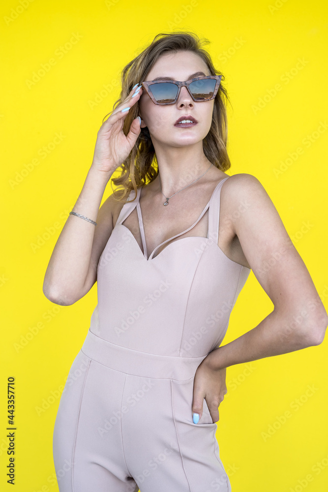 Fototapeta premium portrait of fashion beautiful young woman in beige suit isolated of yellow background