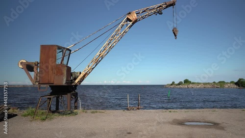 Crane in the port of Engure for fishing boats in the Baltics. Used for lifting fish catch and loading heavy loads. Fishing village in Kurzeme, Latvia. Quiet edge on a sunny summer day photo