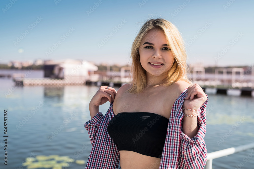 portrait of pretty teenage girl in near a city pond, summer time