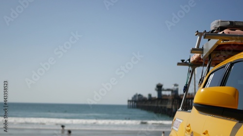 Yellow lifeguard car, Oceanside beach, California USA. Coastline rescue life guard pick up truck, lifesavers vehicle. Iconic auto and ocean coast. Los Angeles vibes, summertime aesthetic atmosphere.
