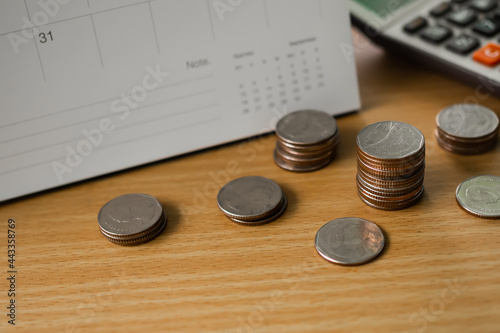 Stack thai coin with calculator and calendar on wood background. planing earn investment and saving money future for 2022 new year. finance and business concept. photo