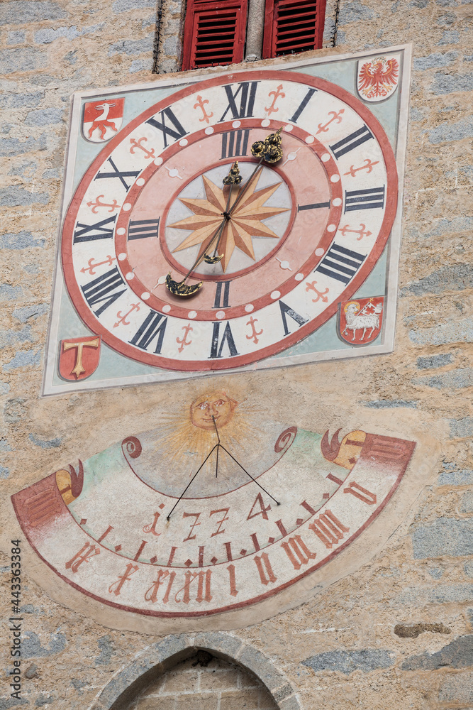 The recently restored clock and  sundial painted outside the bell tower of the church of the town.