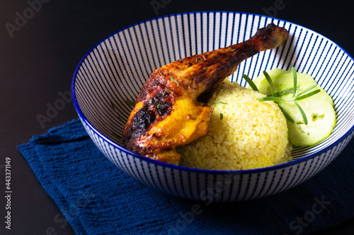 Food concept roasted chicken qaurter and turmeric rice on black background with copy space photo