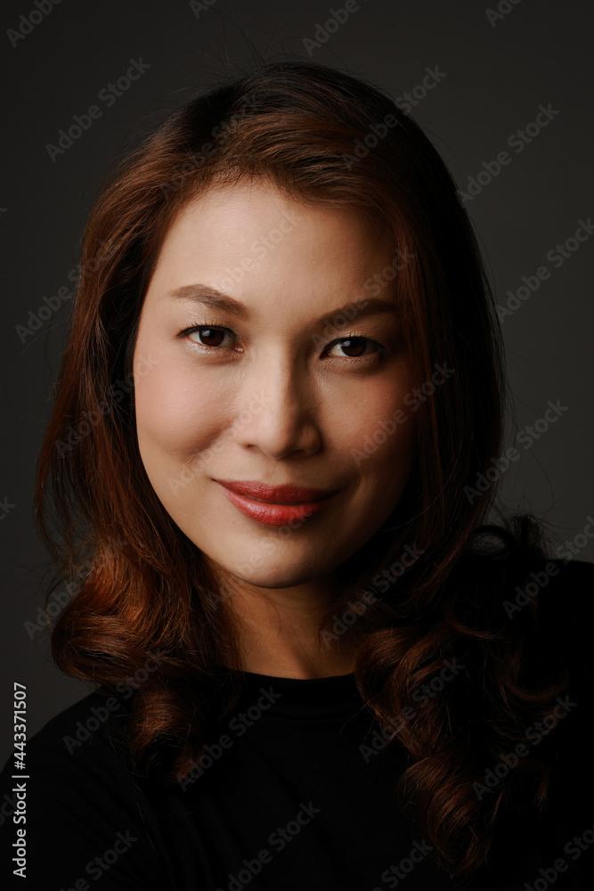 Portrait of beautiful Asian woman smiling and looking to camera with self confident and positive emotion