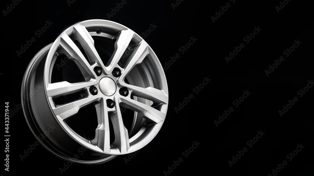 new beautiful silver alloy wheel on a black background. copy space