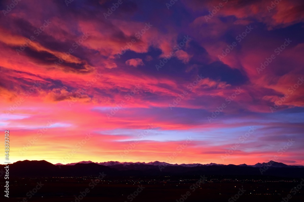 spectacular pastel-colored sunset over long's peak and the front range of the colorado rocky mountains, as seen form broomfield, colorado