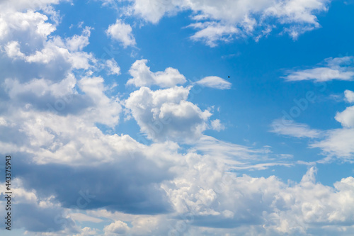 Blue bright sky with white cumulus clouds on a hot summer day
