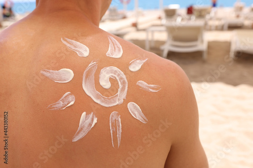 White sun painted on man back with sunscreen closeup