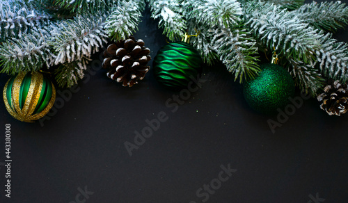 New Year's composition. Fir branches, balls and cones on a black background © SEA_Ekaterina
